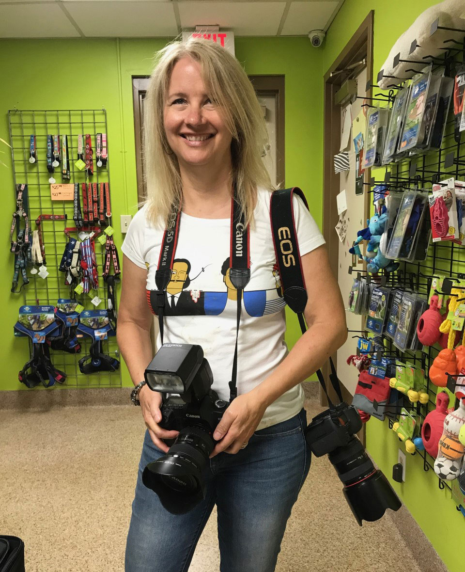 Photographer with two cameras over her shoulder in pet store