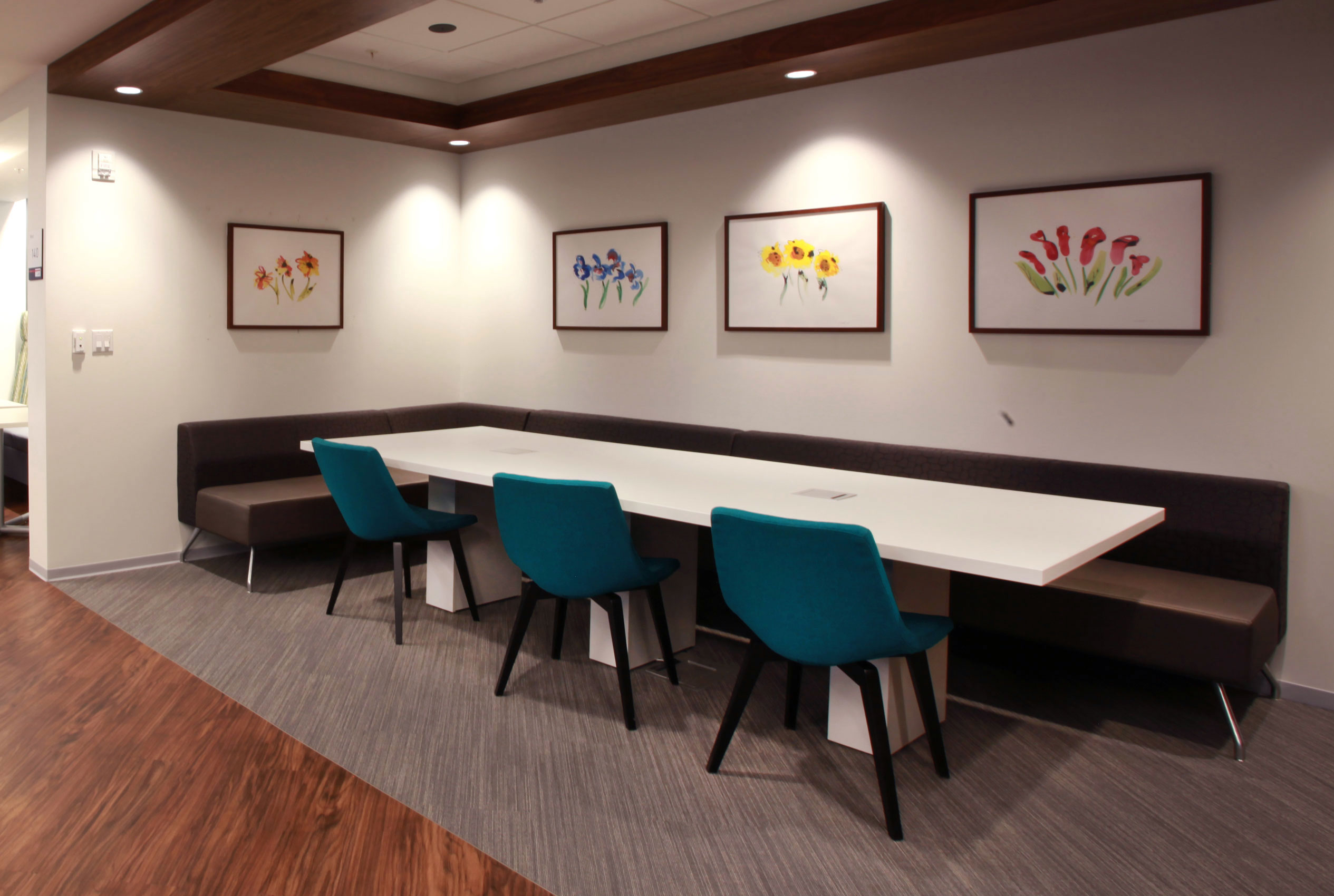 Conference table in cafeteria with four paintings of flowers