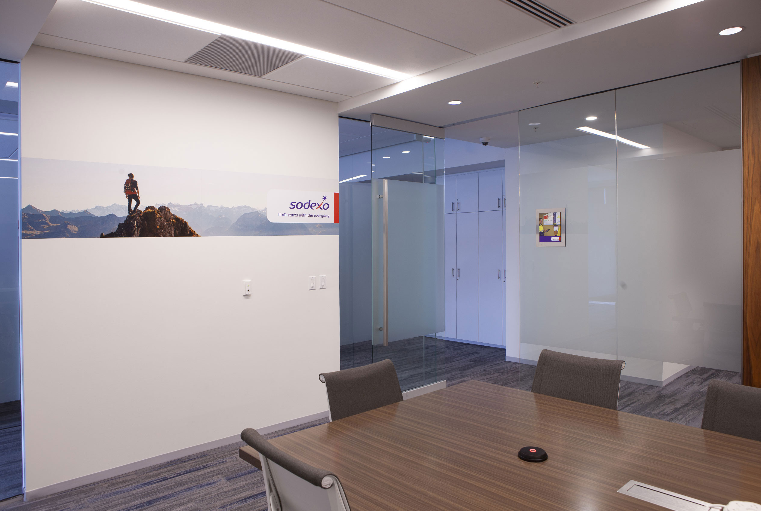 Conference room with photo of man on mountain and glass walls