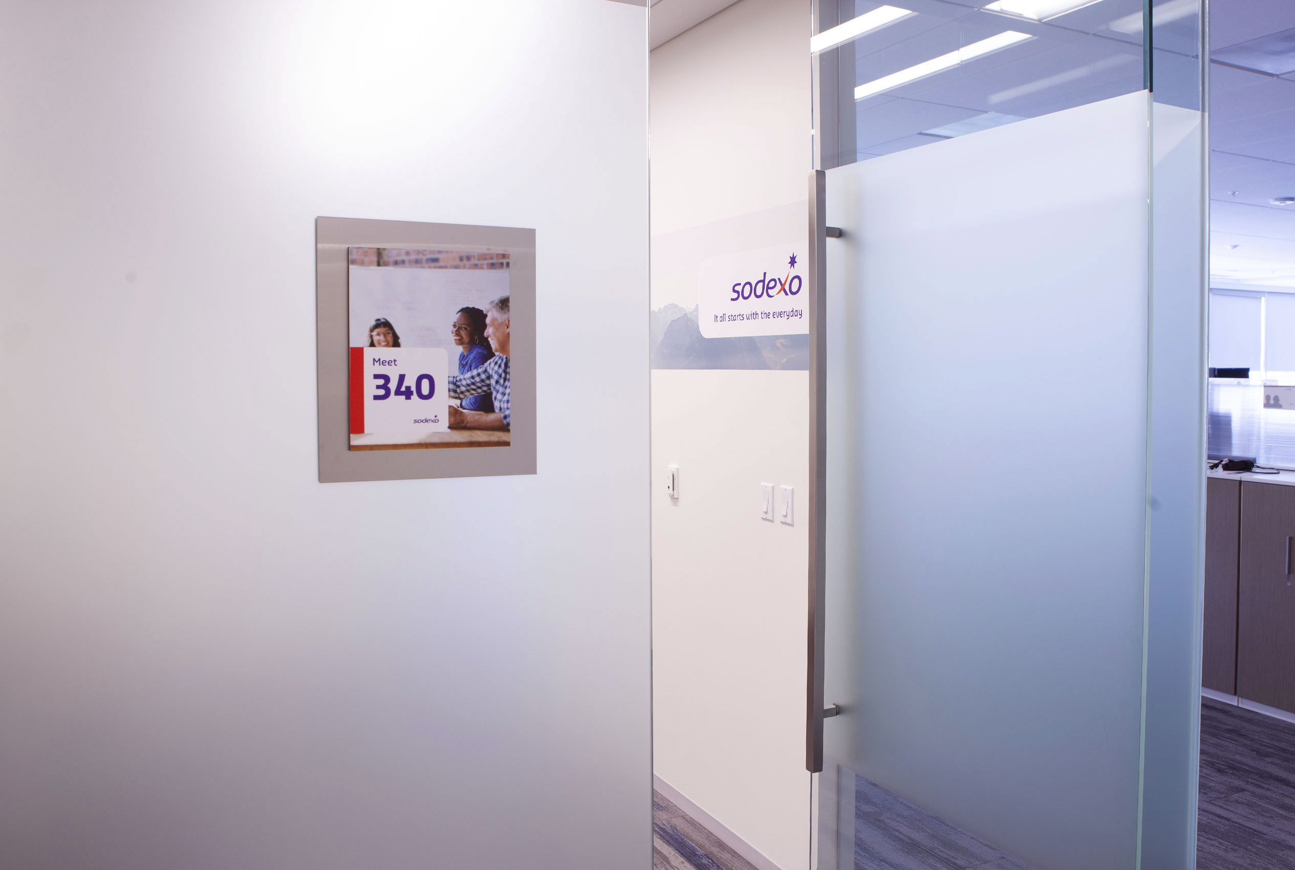 Entrance to conference room with frosted glass door and photo of boat on ocean