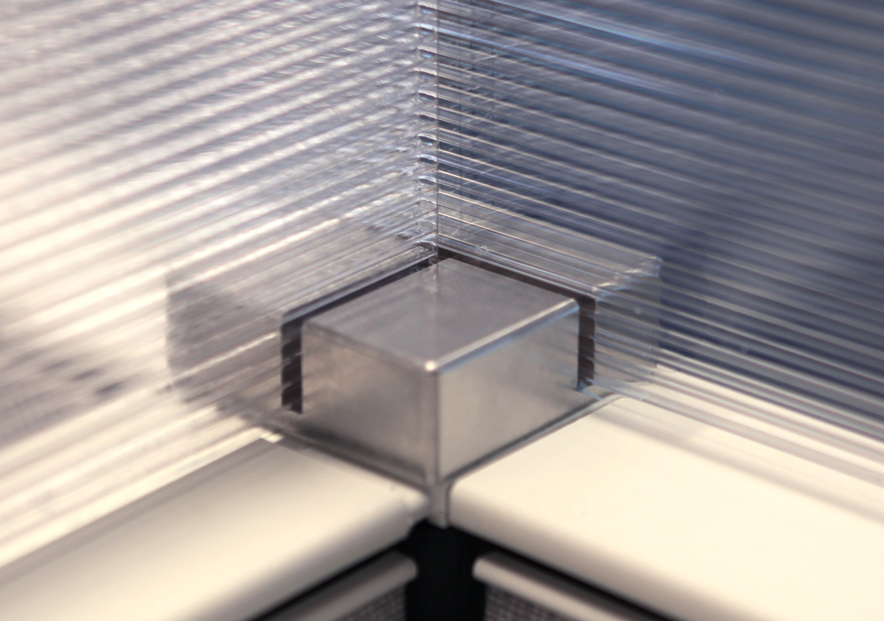 Detail of custom aluminum hardware joining four pieces of plexiglass
